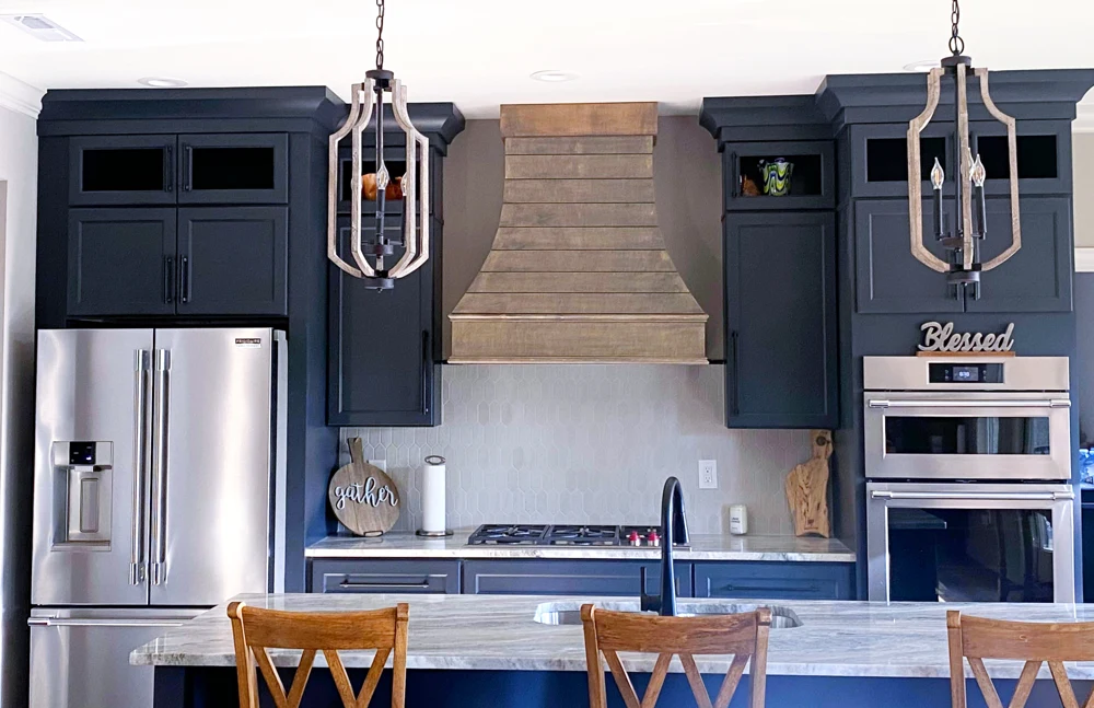 Wood shiplap hood surrounded by deep blue cabinets
